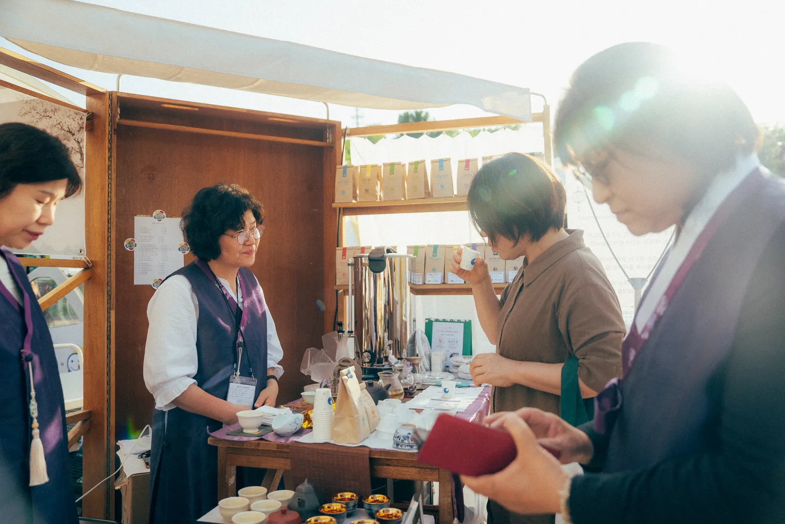 참여 브랜드 부스 — 원목 매대와 다과 구성
